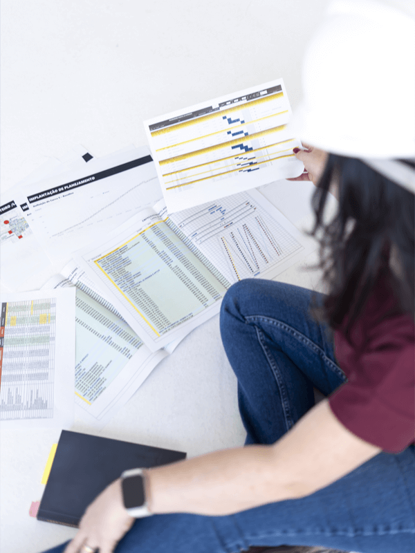 Giovana Albuquerque sentada no chão com vários documentos